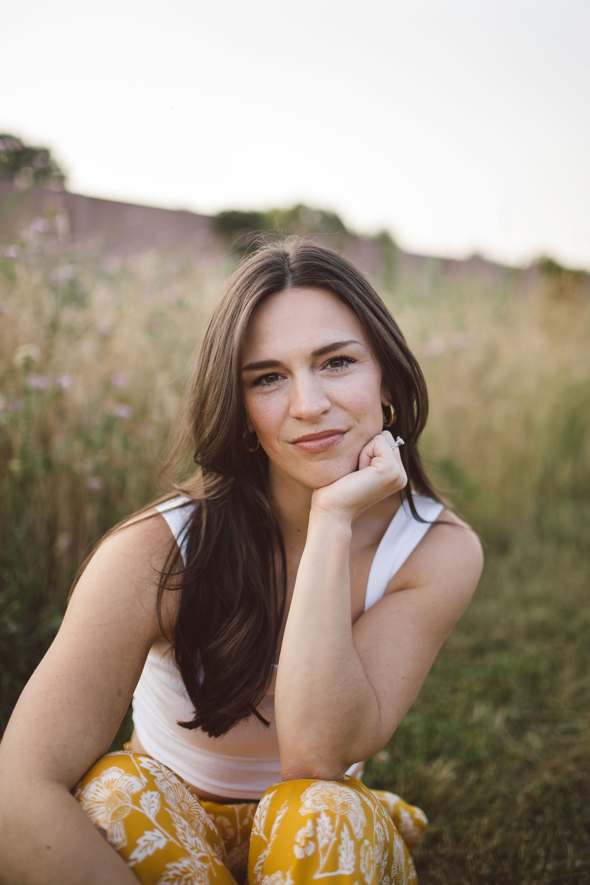 a headshot of amanda marie harner sitting in tall grass